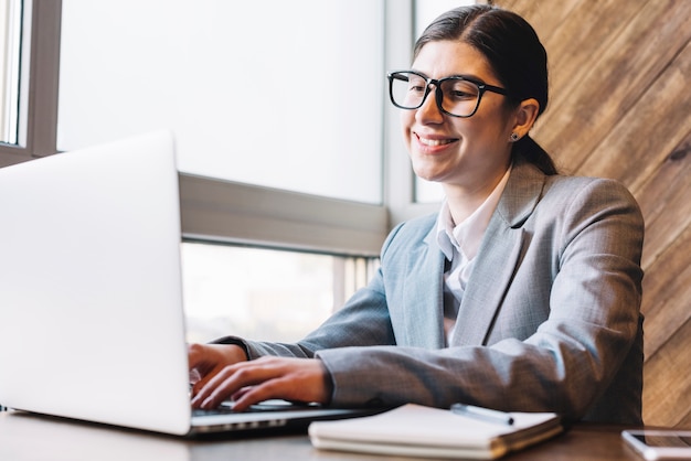 Gratis foto onderneemster met laptop in koffiewinkel