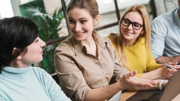 Gratis foto ondernemers tijdens een vergadering binnenshuis met behulp van laptop