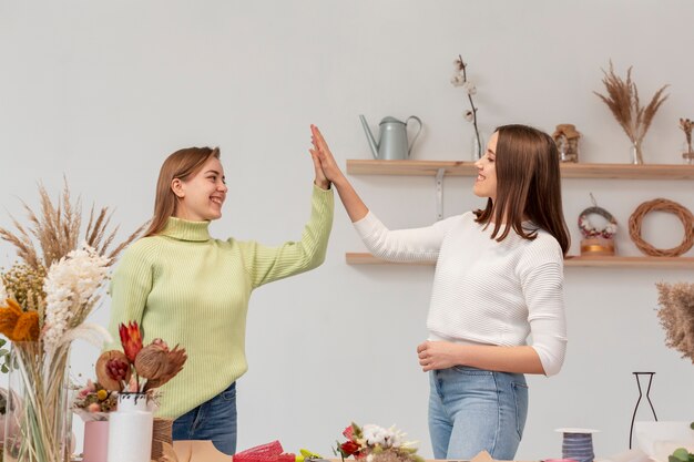 Ondernemersvrouwen in hun kleine bedrijf high five