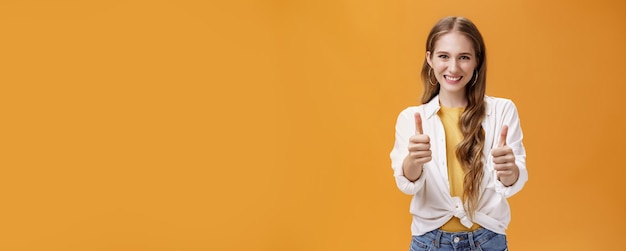 Gratis foto ondersteunende charmante jonge vriendin in trendy outfit en oorbellen met golvende kastanjebruine kapselshow