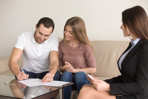 Ondertekening overeenkomst over ontmoeting met makelaar, paar kopen huurappartement