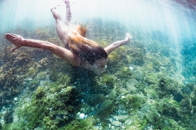 Gratis foto onderwaterfoto van vrouw duiken