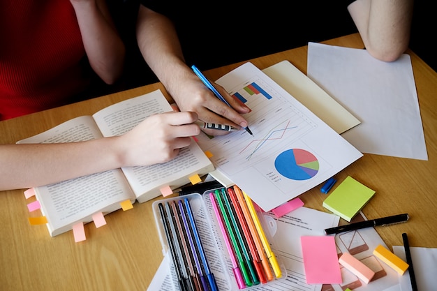 Onderwijsconcept. Studenten bestuderen en brainstormen campus concept. Close-up van studenten die hun onderwerp bespreken op boeken of handboeken. Selectieve focus.