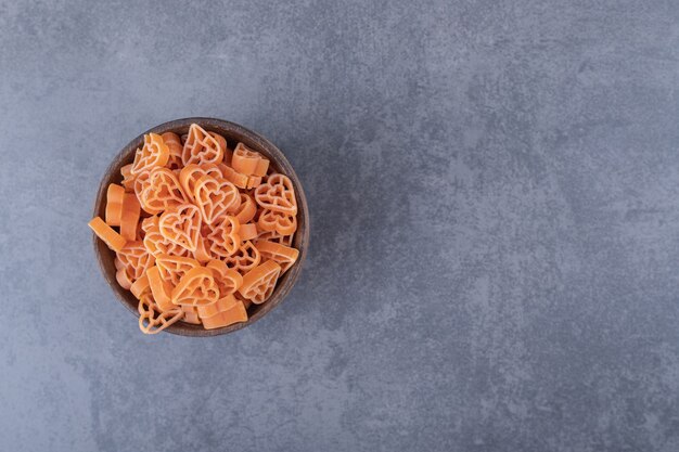 Ongekookte hartvormige pasta in houten kom.