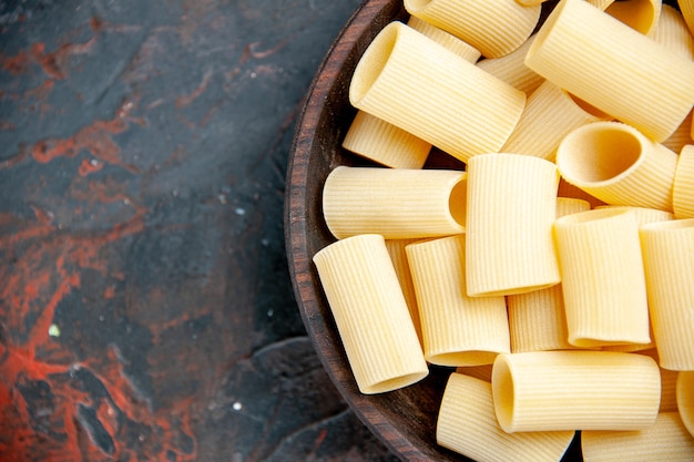 Ongekookte pasta's in de pot op zwarte tafel