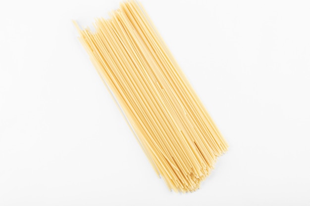 Ongekookte spaghettideegwaren op witte achtergrond. Hoge kwaliteit foto