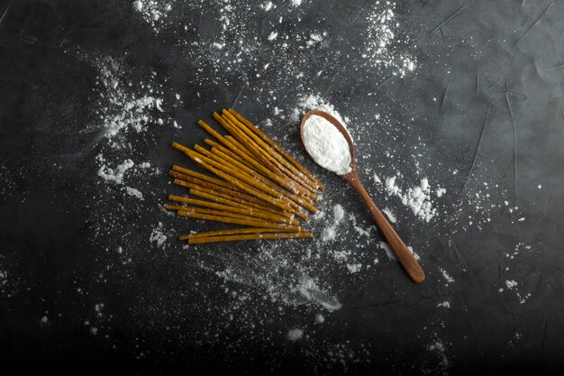 Ongekookte spaghetties met bloem in een houten lepel