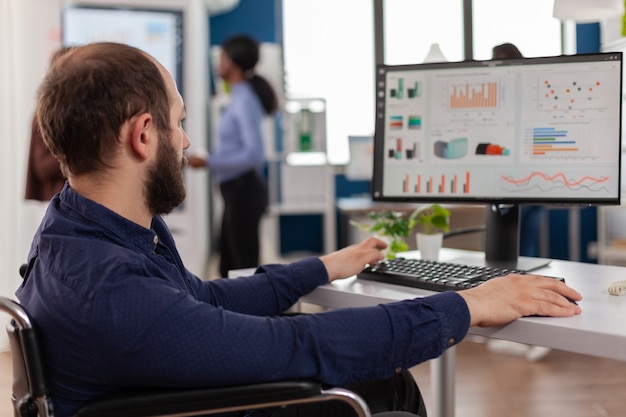 Ongeldige werknemer met een handicap die op de computer werkt