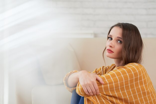 Ongelukkige vrouw in depressieve stemming om thuis te zitten