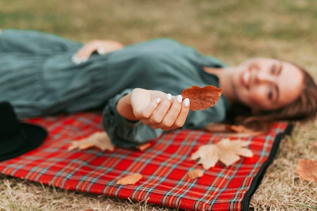 Ongericht vrouw met bladeren op een picknickkleed