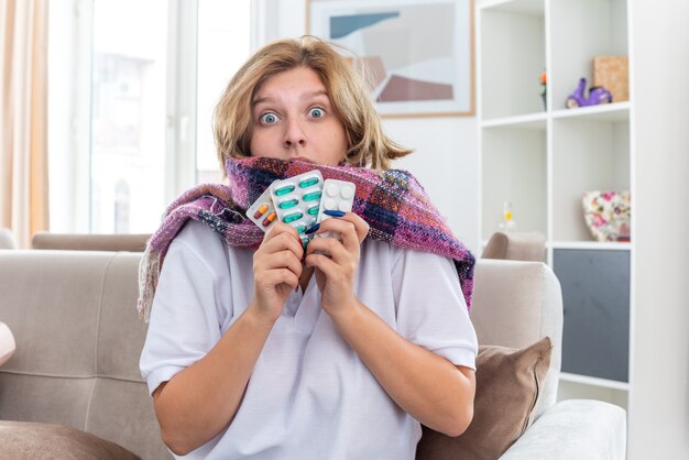 Ongezonde vrouw met warme sjaal om nek die zich onwel en ziek voelt en lijdt aan griep en verkoudheid