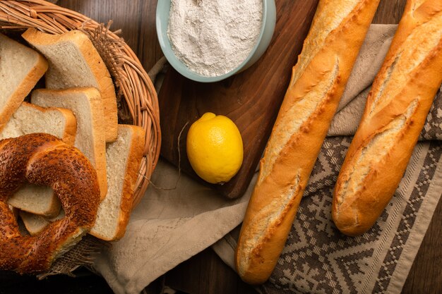 Ongezuurd broodje en brood in mand met stokbrood en citroen