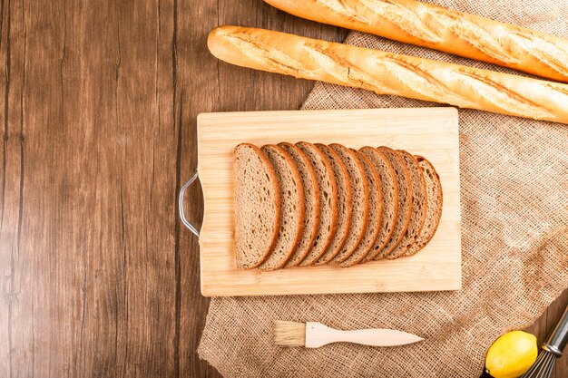 Ongezuurd broodje en plakken van donker brood op keukenraad