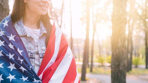 Onherkenbaar vrouwelijk verpakken in Amerikaanse vlag op warme zomerdag