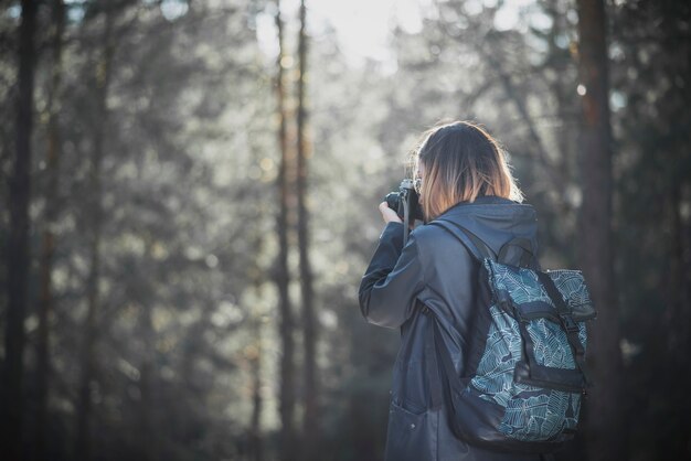 Onherkenbare vrouw die beelden van bos neemt