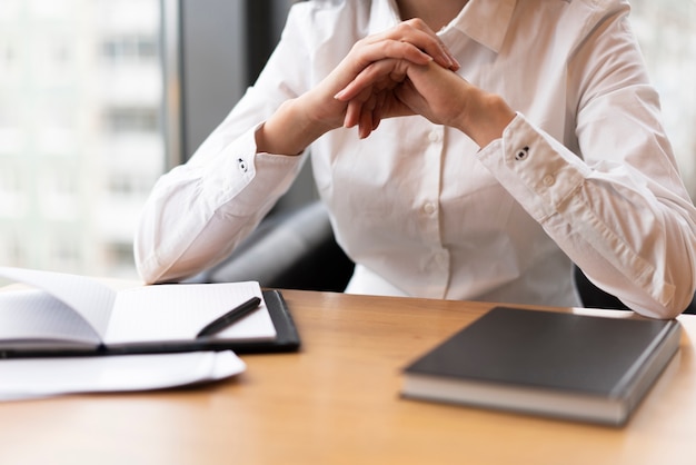 Gratis foto onherkenbare vrouw die in bureau denkt