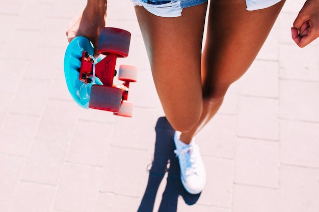 Onherkenbare vrouw die met skateboard loopt