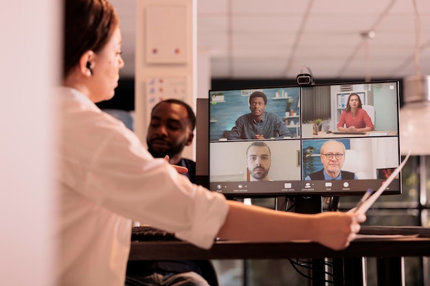 Online briefing van het bedrijfsteam, presentatiediscussie over videogesprek, vrouw die online videoconferentie op computer bijwoont. teleconferentie van collega's in coworking-ruimte 's nachts