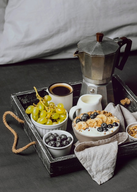 Ontbijt op bed met bosbessen en ontbijtgranen op dienblad