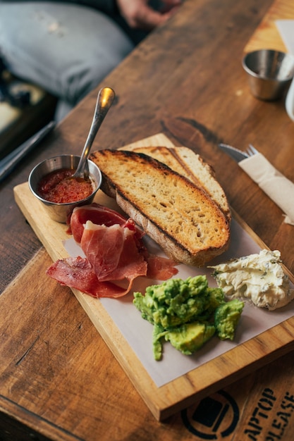 Gratis foto ontbijt toast met ham en avocado aan boord