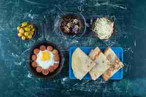 Gratis foto ontbijtbord met gebakken eieren, worst en pannenkoeken.