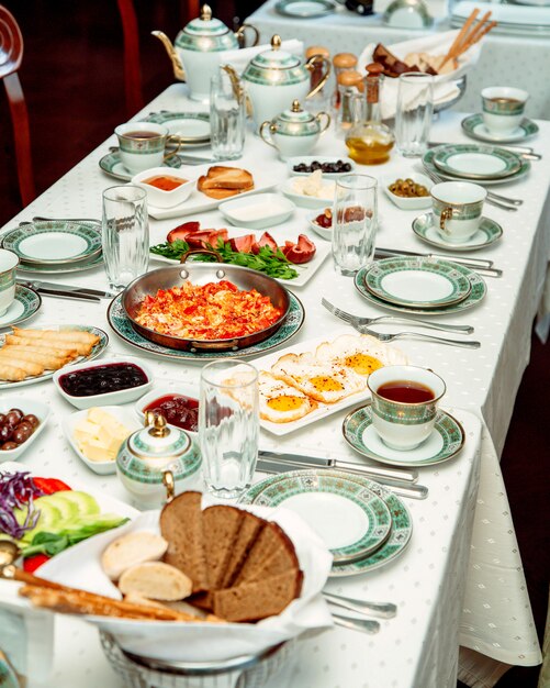 Ontbijttafel met ei schotel roerei brood worstjes kaas en jam