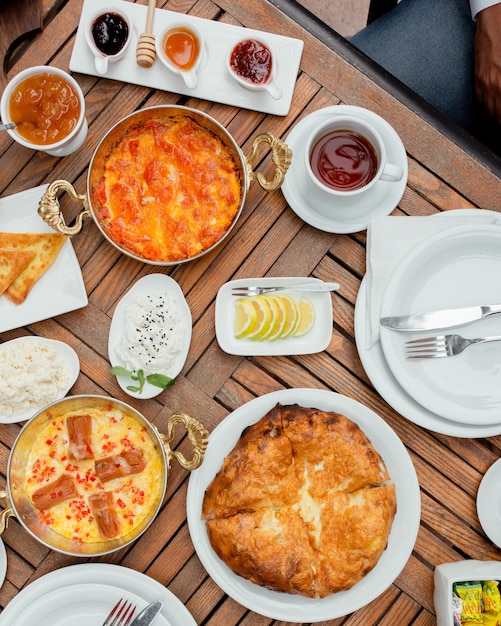 Ontbijttafel met verschillende soorten voedsel en kopje thee.