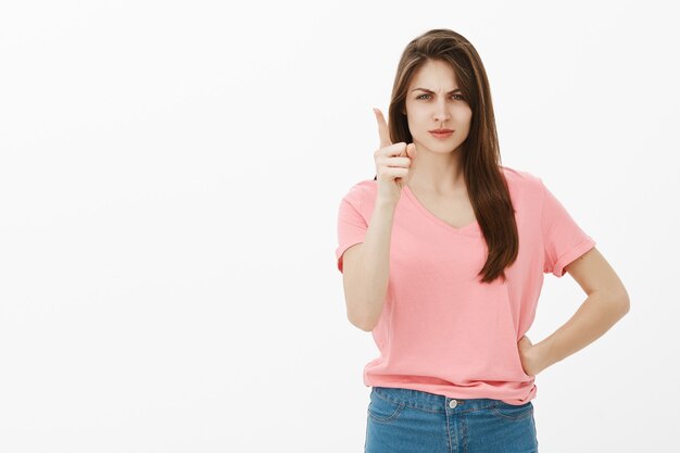 Ontevreden en boos brunette vrouw poseren in de studio