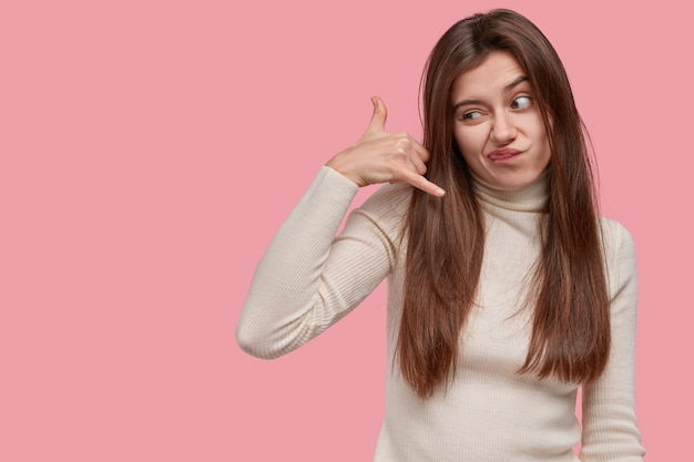 Ontevreden jonge mooie dame gebaren binnen, maakt roepnaam met hand