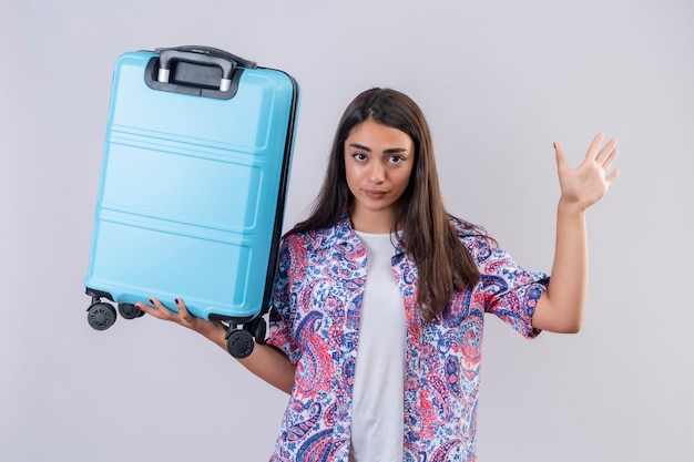 Ontevreden jonge mooie reiziger vrouw met koffer permanent met open hand stop gebaar maken