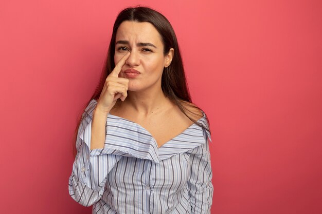 Ontevreden vrij blanke vrouwenvinger op neus op roze