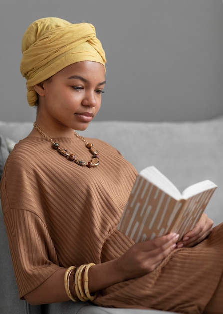 Ontspannen Arabische vrouw die thuis een boek leest