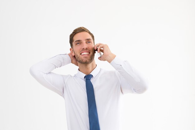 Ontspannen bedrijfsmens die op mobiele telefoon spreekt