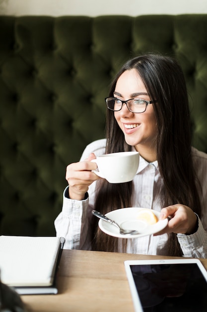 Ontspannen vrouw die koffie heeft terwijl het bestuderen