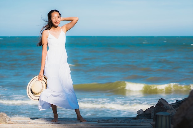 Ontspant de mooie jonge Aziatische vrouwen gelukkige glimlach van het portret rond neary strand en overzees