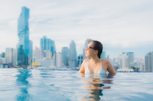 Ontspant de portret mooie jonge Aziatische vrouw gelukkige glimlachvrije tijd rond openluchtzwembad