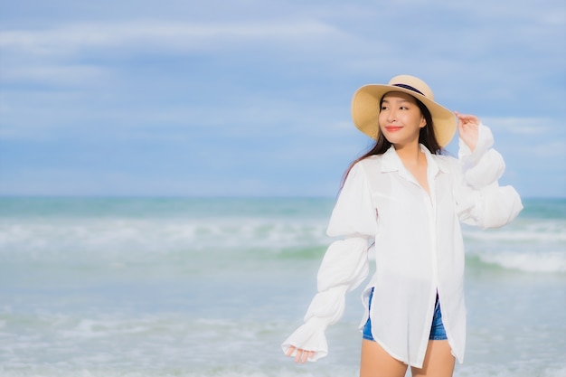 Ontspant de portret mooie jonge aziatische vrouw glimlach rond strand overzeese oceaan in de reisreis van de vakantievakantie