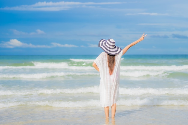 Ontspant de portret mooie jonge aziatische vrouw glimlach rond strand overzeese oceaan in de reisreis van de vakantievakantie