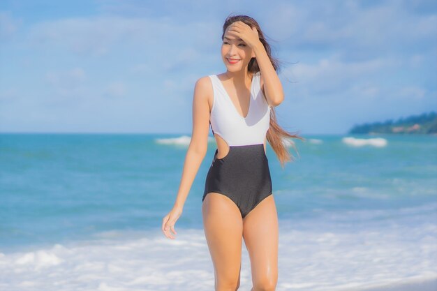 Ontspant de portret mooie jonge Aziatische vrouw glimlach rond strand overzeese oceaan in vakantievakantie