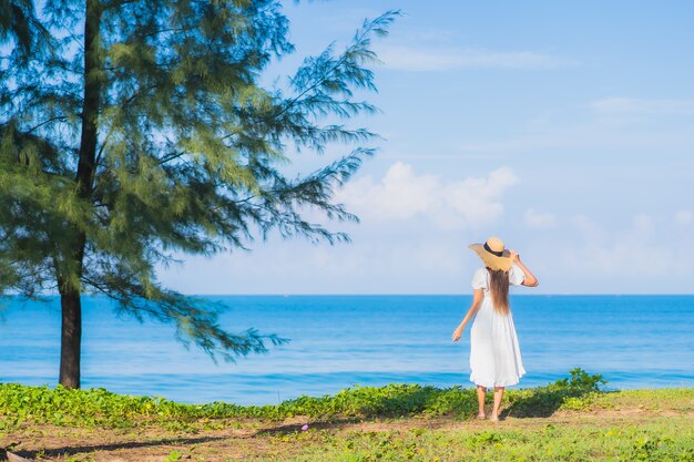 Ontspant de portret mooie jonge aziatische vrouw glimlach rond strand overzeese oceaan met blauwe hemel witte wolk voor reisvakantie