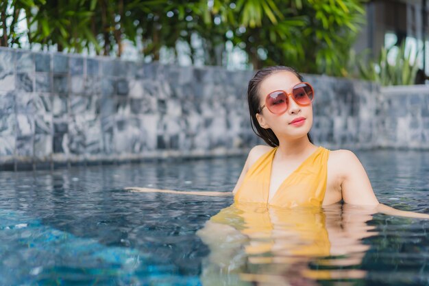 Ontspant de portret mooie jonge Aziatische vrouw vrije tijd rond zwembad