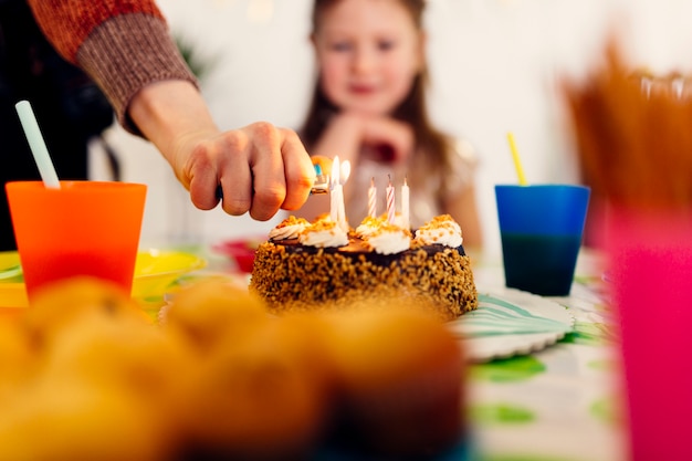 Gratis foto ontsteking van kaarsen op verjaardagstaart