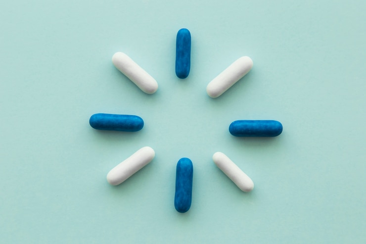 Gratis Foto ontwerp gemaakt met blauwe en witte capsules op lege achtergrond