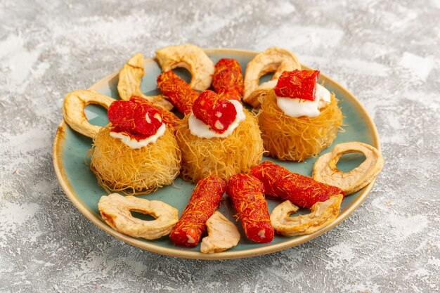 oostelijke gebakjekoekjes in groene plaat met witte room, gedroogd fruit en kleine confitures