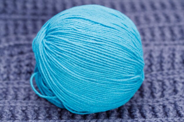 Op een blauw wollen tafelkleed ligt een blauwe bol wol. hoge kwaliteit foto