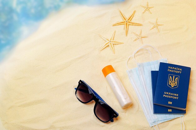 Op het zand bij de zee zijn er paspoorten zeester zonbescherming crème zonnebril