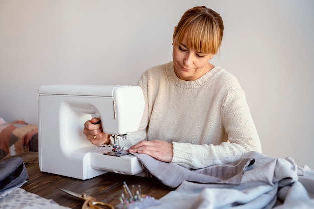 Op maat vrouw met behulp van naaimachine