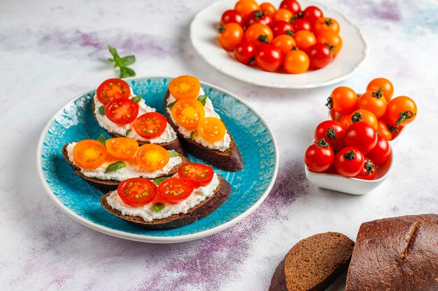 Open sandwiches met kwark, cherrytomaatjes en basilicum.