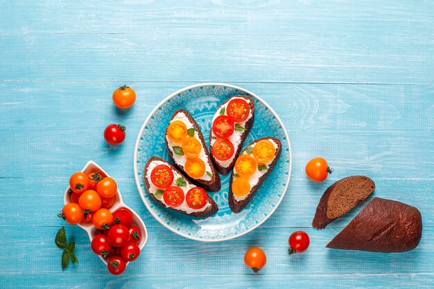 Open sandwiches met kwark, cherrytomaatjes en basilicum.