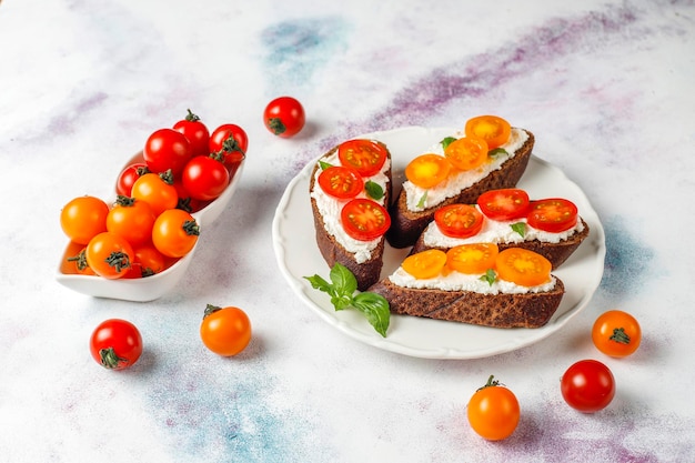 Open sandwiches met kwark, cherrytomaatjes en basilicum.